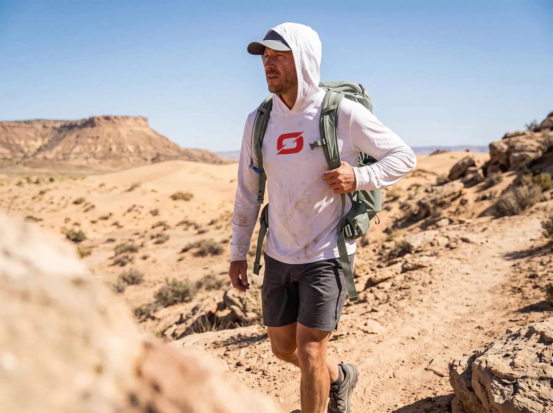 A hiker in an Origin shirt on a desert trail.
